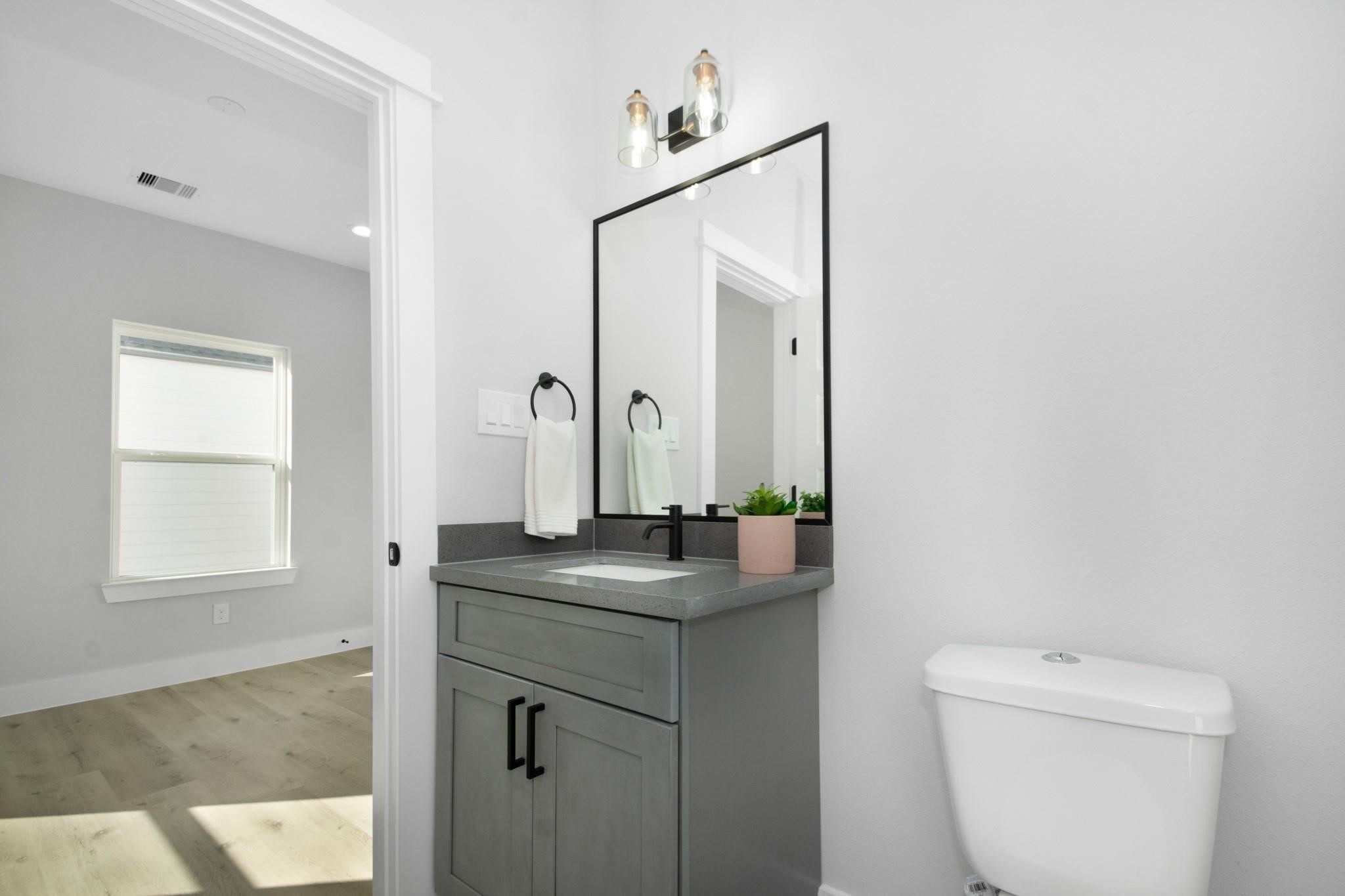 2105 Sam Wilson Street, Unit A Houston, TX 77020 - Photo 15 of 20 a bathroom with a granite countertop sink and a mirror