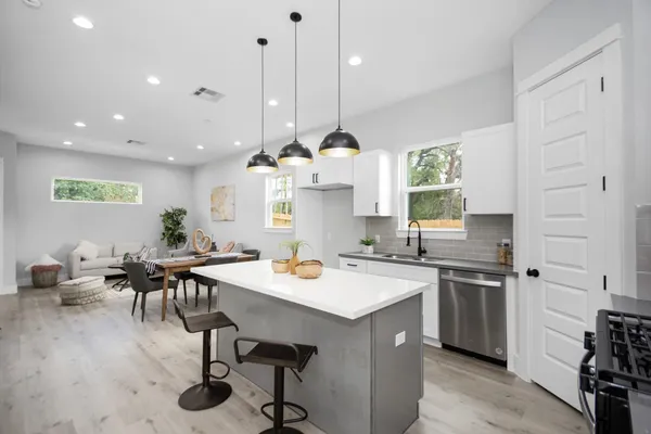 a kitchen with a table chairs sink and cabinets
