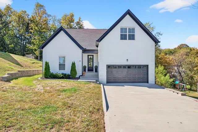 a view of a house with a yard and potted plants