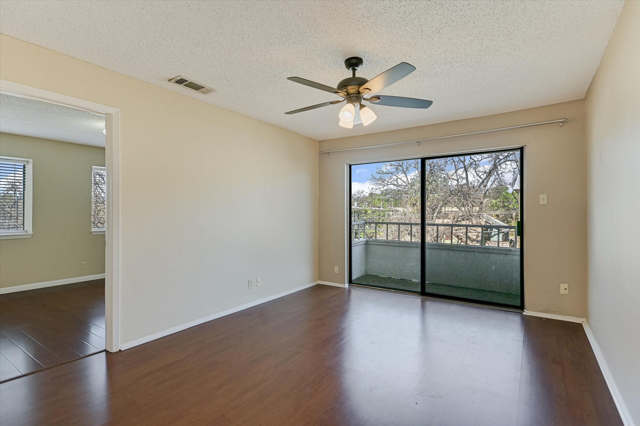 3115 Helms Street, Unit 112 Austin, TX 78705 - Photo 5 of 13 an empty room with wooden floor fan and windows