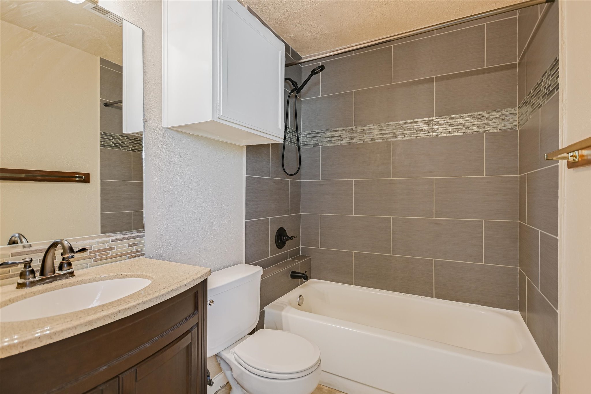 3115 Helms Street, Unit 112 Austin, TX 78705 - Photo 9 of 13 a bathroom with a bathtub shower sink mirror vanity and toilet