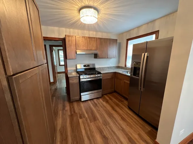 a kitchen with stainless steel appliances a refrigerator a sink a stove and cabinets