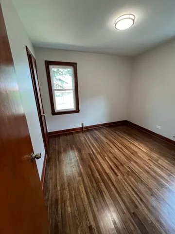 an empty room with wooden floor and entrance