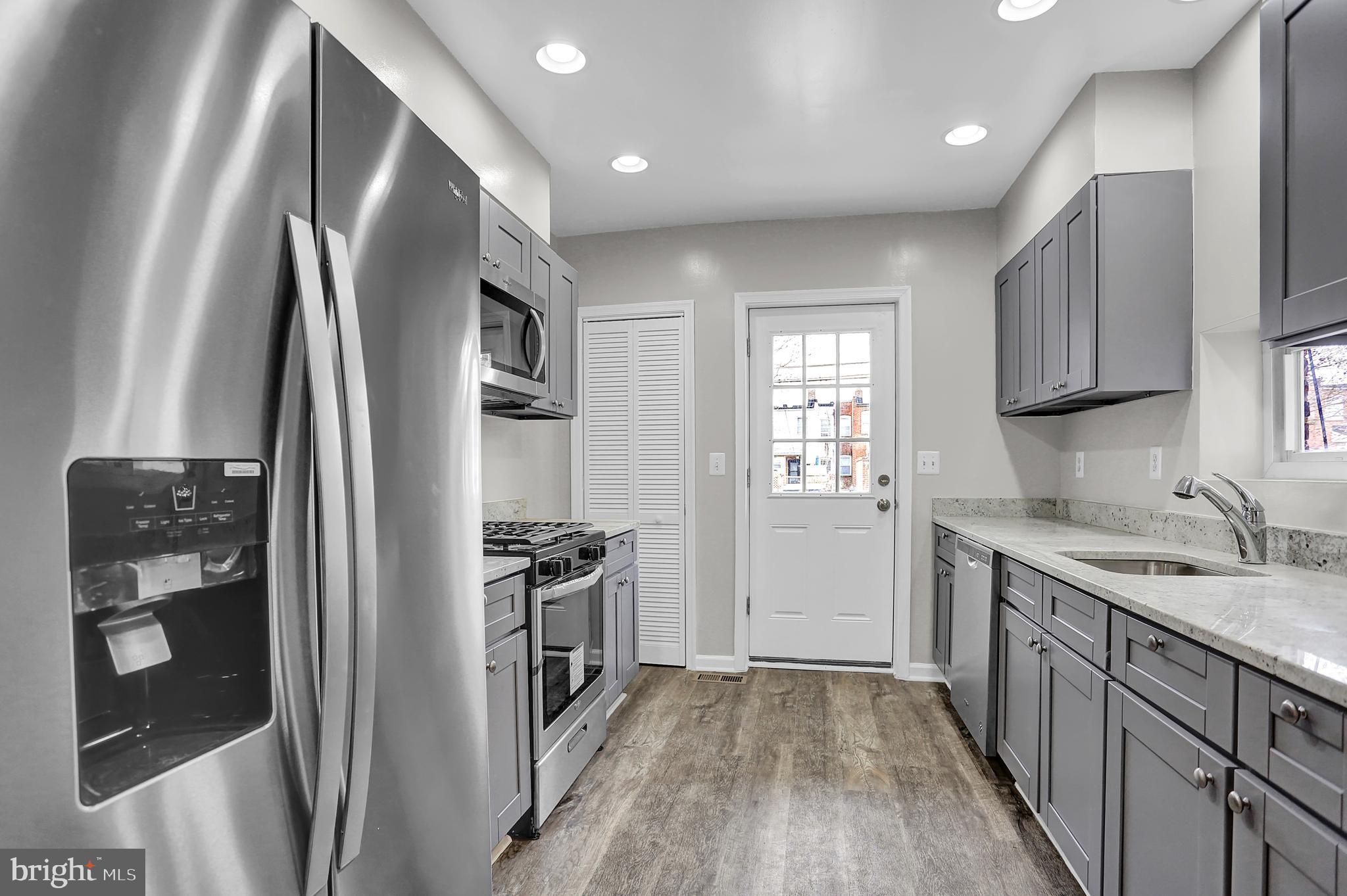 7025 Dunbar Road Dundalk, MD 21222 - Photo 12 of 27 a kitchen with stainless steel appliances granite countertop a refrigerator and a sink