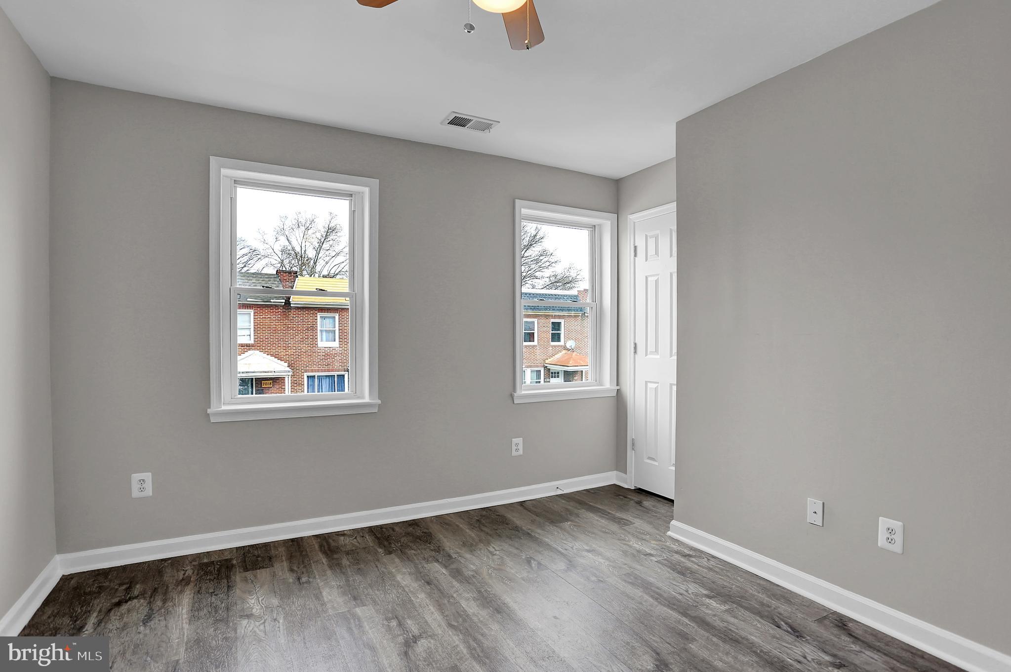 7025 Dunbar Road Dundalk, MD 21222 - Photo 17 of 27 an empty room with wooden floor and windows