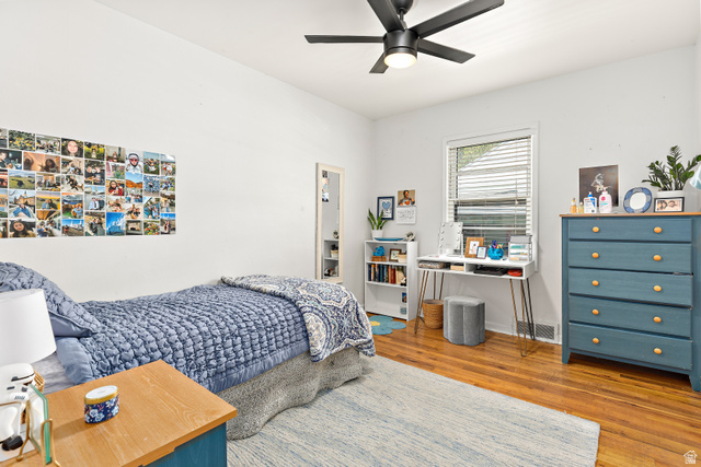 372 800 East Provo, UT 84606 - Photo 11 of 29 Hardwood flooring throughout this bright room featuring a ceiling fan with integrated lighting, a window with horizontal blinds, and a built-in bookshelf