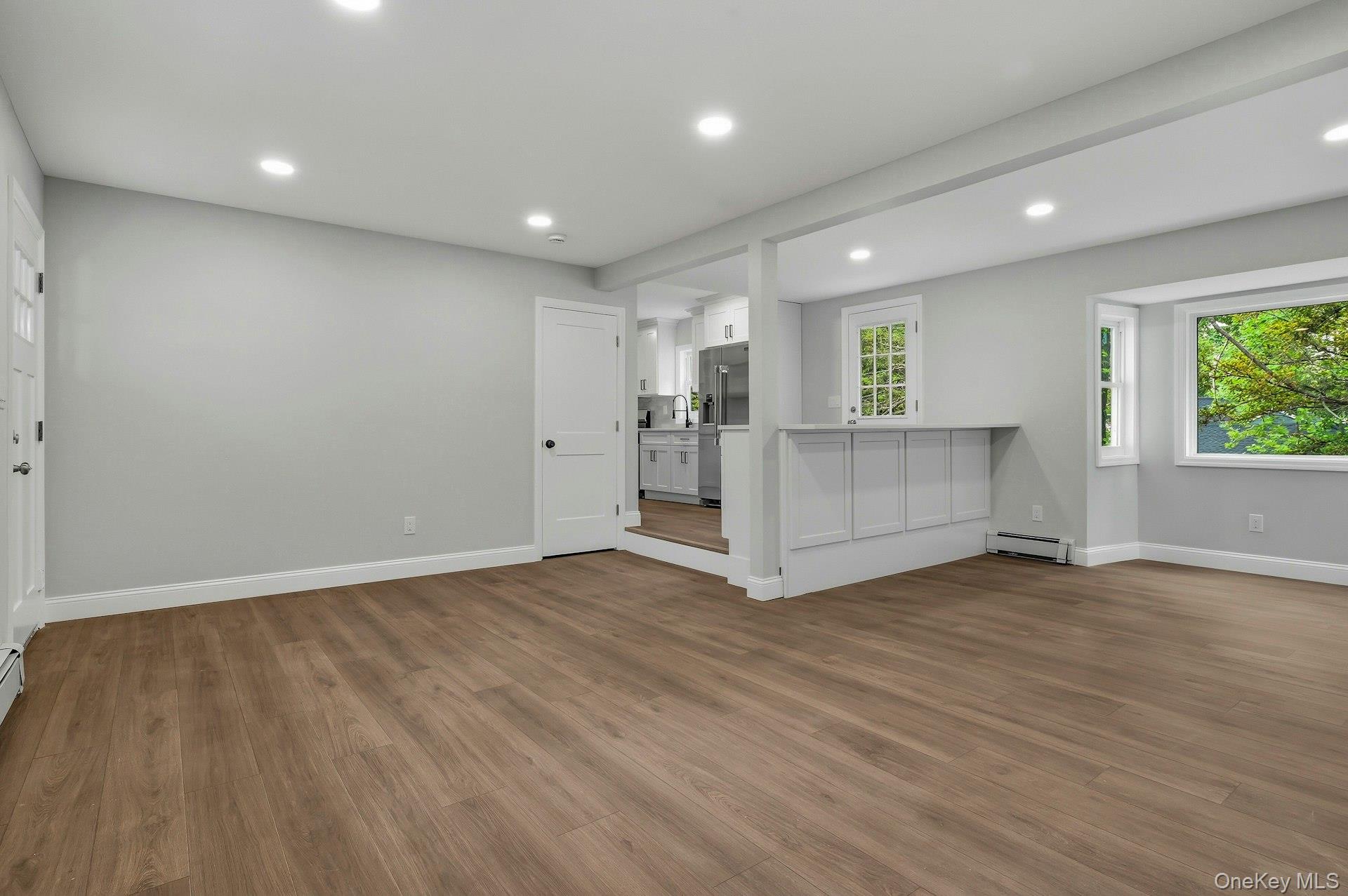 101 Rustic Road Centereach, NY 11720 - Photo 12 of 42 an empty room with wooden floor and windows