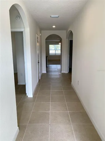 a view of a hallway with wooden floor and a bathroom