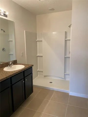 a bathroom with a bathtub sink vanity and mirror