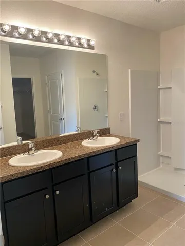 a bathroom with double vanity and a mirror