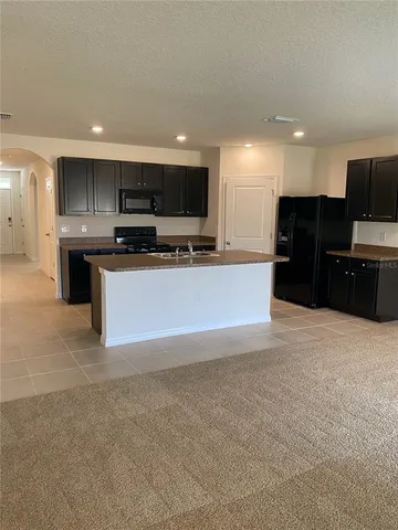 a large white kitchen with a sink and a microwave