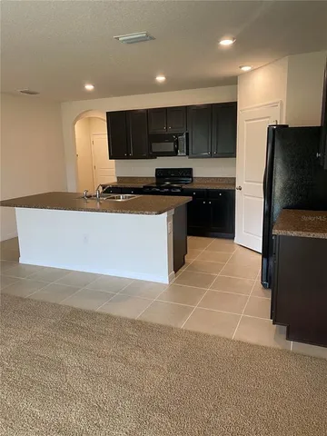 a kitchen with stainless steel appliances a refrigerator sink and microwave