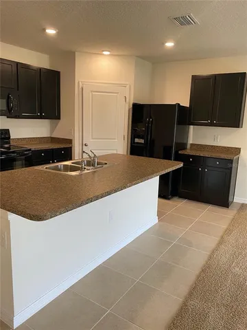 a kitchen with stainless steel appliances a sink a stove a microwave a counter top and space