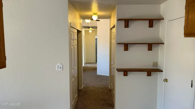 a view of a hallway with wooden floor and cabinet