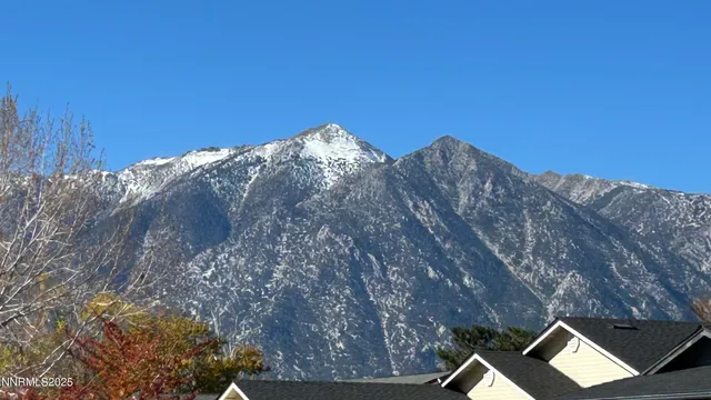 a front door view of a hallway with wooden floor