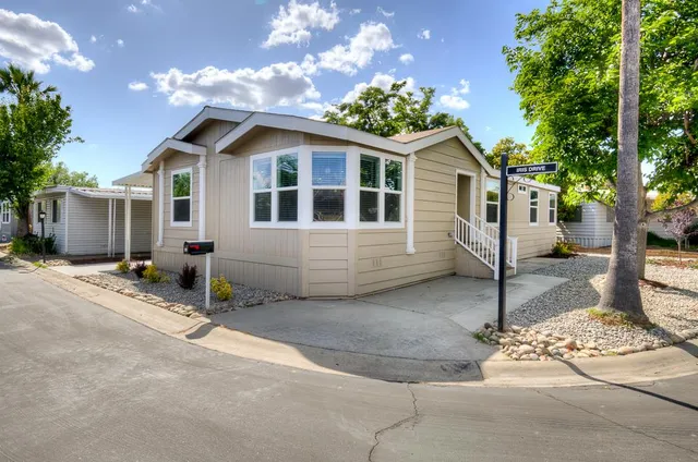 a front view of a house with a tree