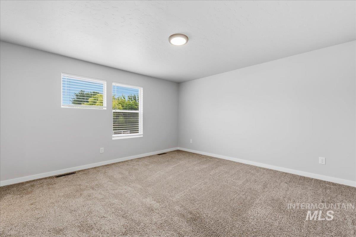 12475 West Victory Road Boise, ID 83709 - Photo 15 of 26 Spacious room with plush carpeting and light gray wall finishes