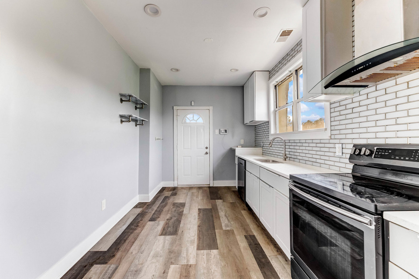 7759 South Constance Avenue Chicago, IL 60649 - Photo 13 of 26 a kitchen with a sink and wooden floor