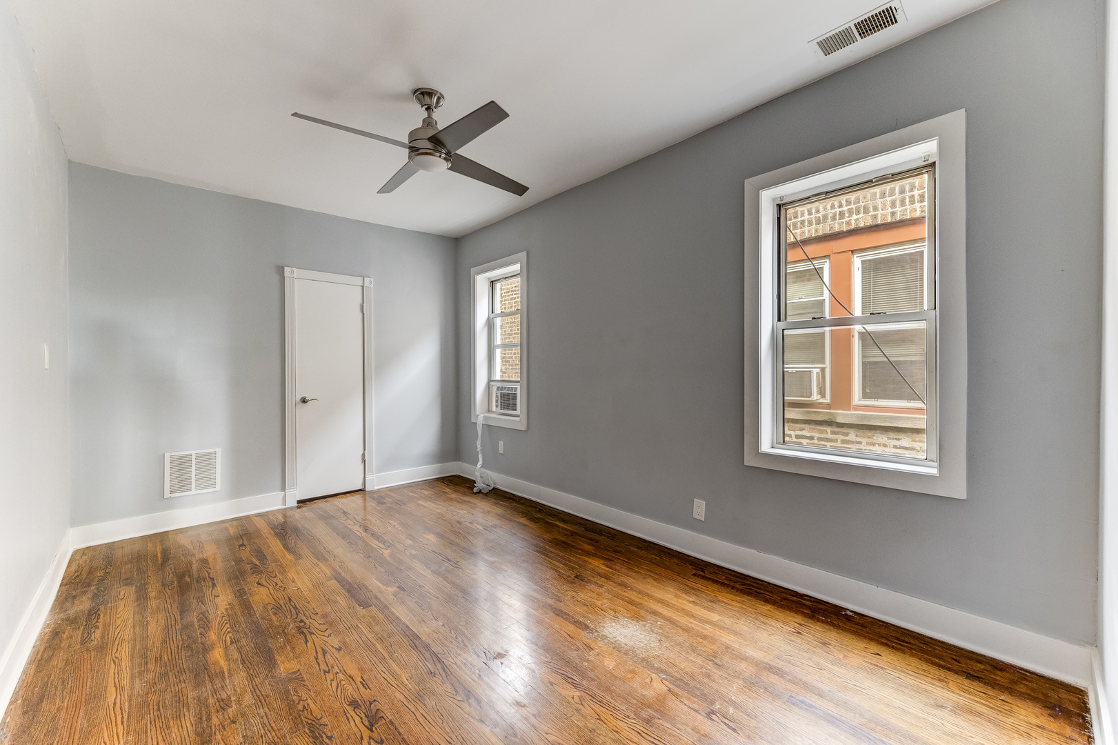 7759 South Constance Avenue Chicago, IL 60649 - Photo 17 of 26 a view of an empty room with wooden floor and a window