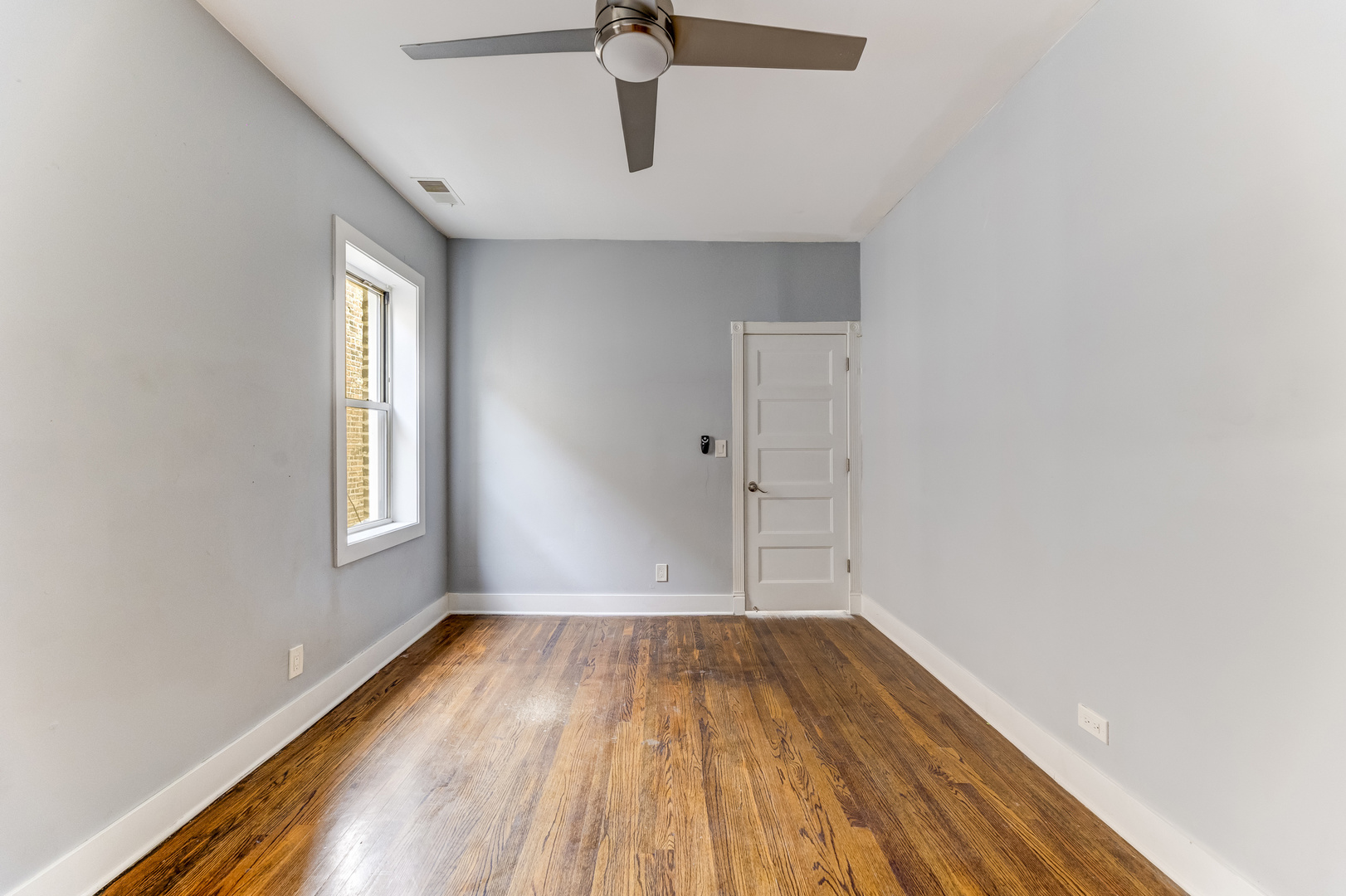 7759 South Constance Avenue Chicago, IL 60649 - Photo 18 of 26 a view of room with window and wooden floor