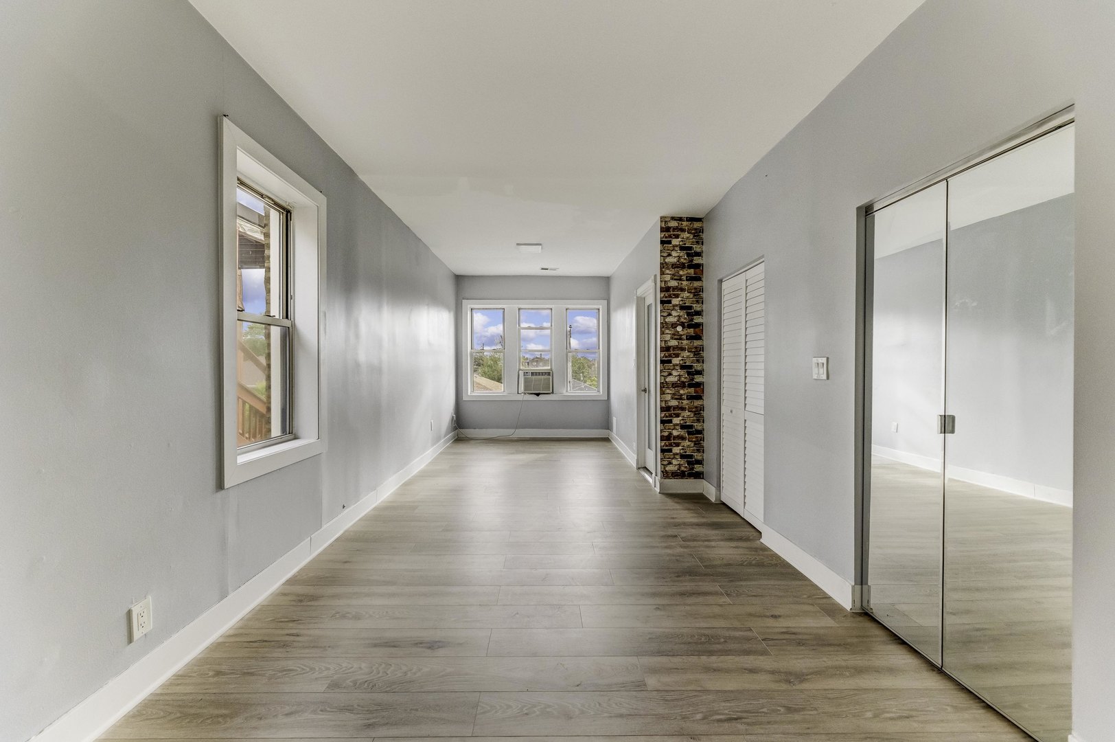 7759 South Constance Avenue Chicago, IL 60649 - Photo 20 of 26 a view of an empty room with wooden floor and windows
