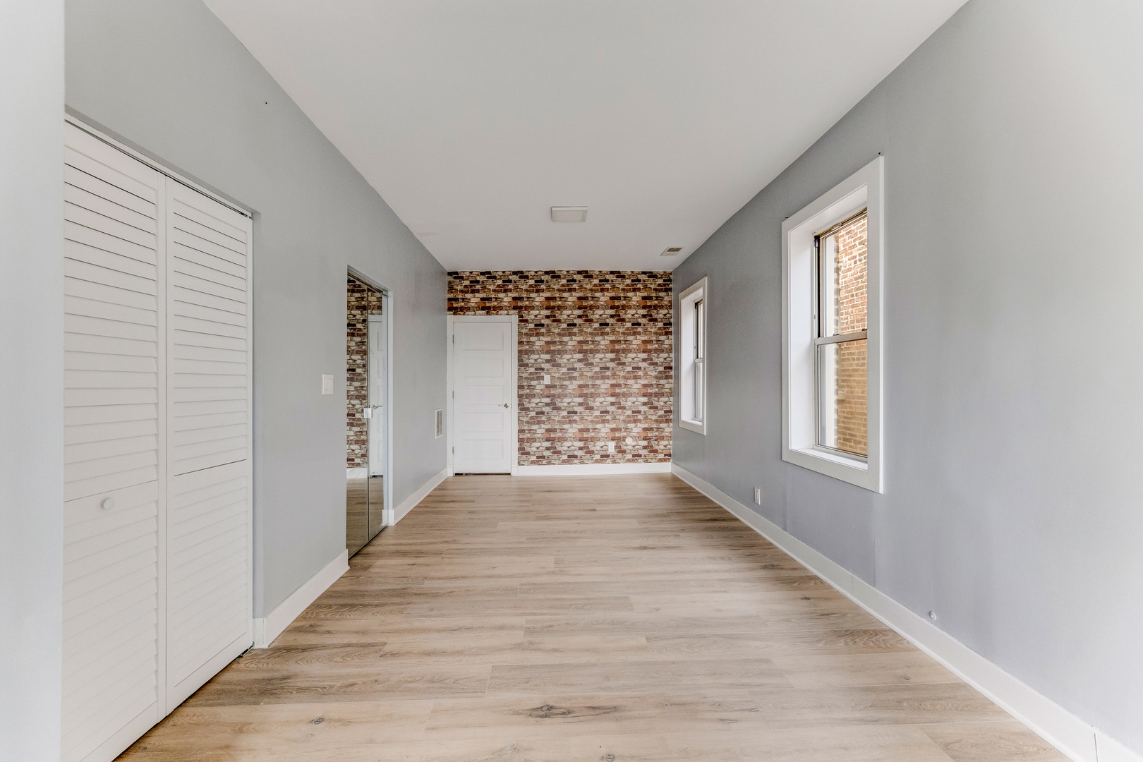 7759 South Constance Avenue Chicago, IL 60649 - Photo 22 of 26 a view of an empty room with a window and wooden floor