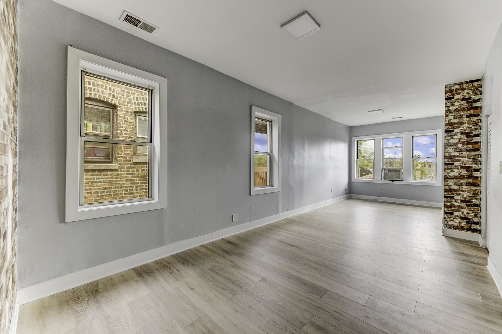 7759 South Constance Avenue Chicago, IL 60649 - Photo 23 of 26 a view of an empty room with window and wooden floor