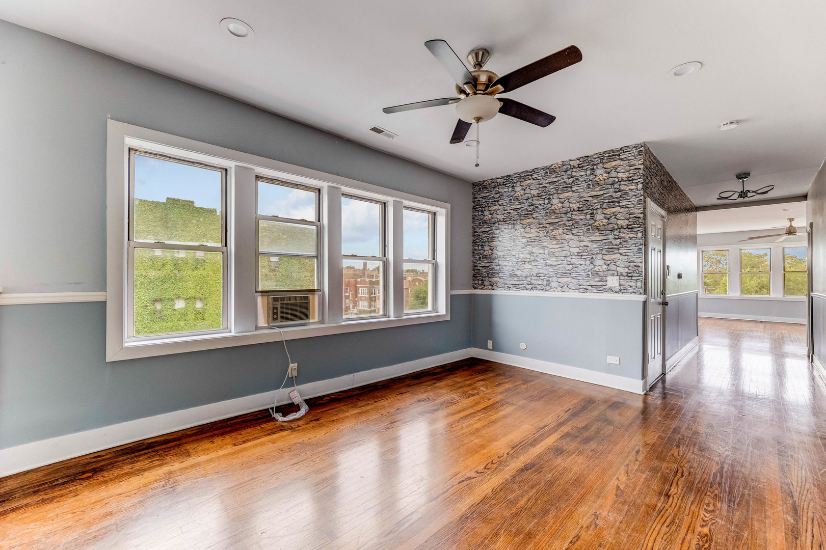 7759 South Constance Avenue Chicago, IL 60649 - Photo 10 of 26 a view of an empty room with a window and wooden floor