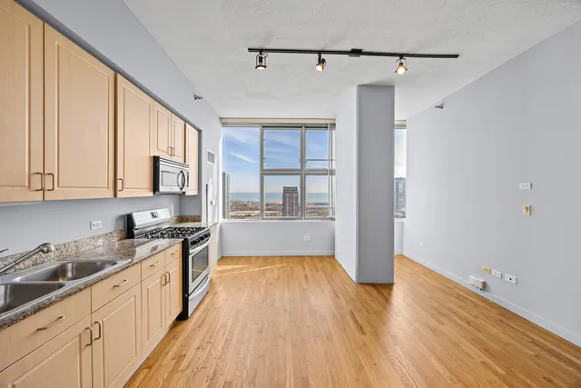 a large kitchen with a wooden floor and cabinets