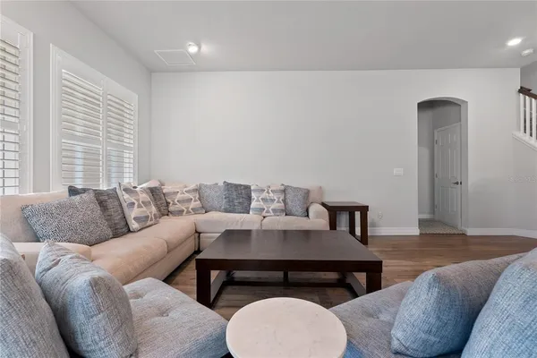 a living room with furniture and a wooden floor