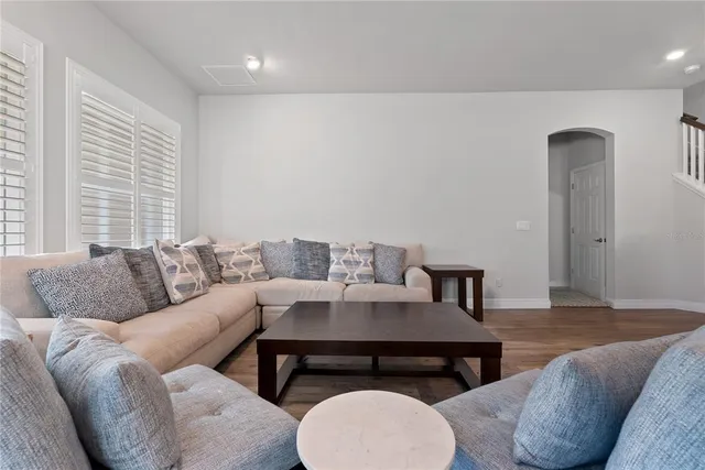 a living room with furniture and a wooden floor