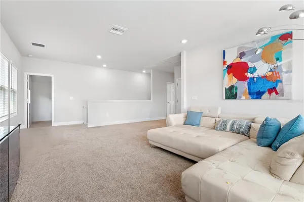 a spacious bedroom with two beds and painting on the wall