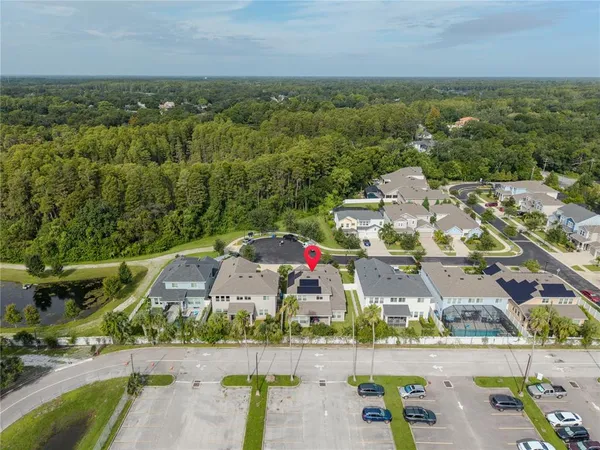 an aerial view of residential houses with outdoor space and ocean view
