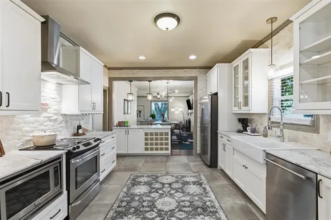a kitchen with stainless steel appliances granite countertop a stove a sink and a refrigerator