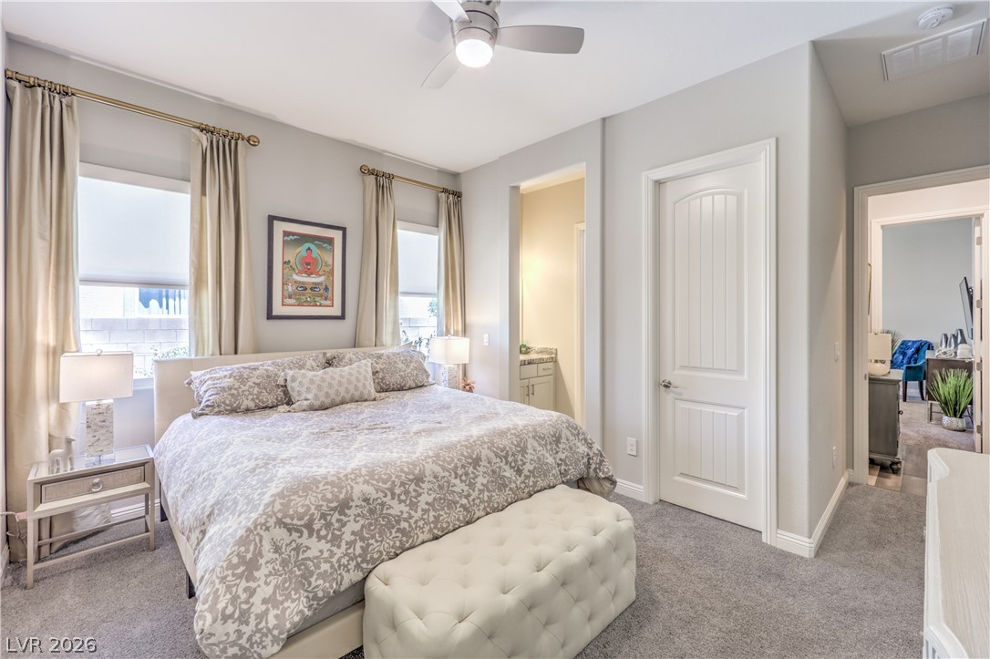 7119 Arabian Ridge Street Las Vegas, NV 89131 - Photo 33 of 73 A well-appointed primary bedroom with soft carpet flooring and elegant window treatments.