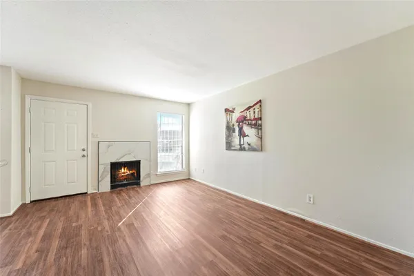a view of empty room with wooden floor and fireplace