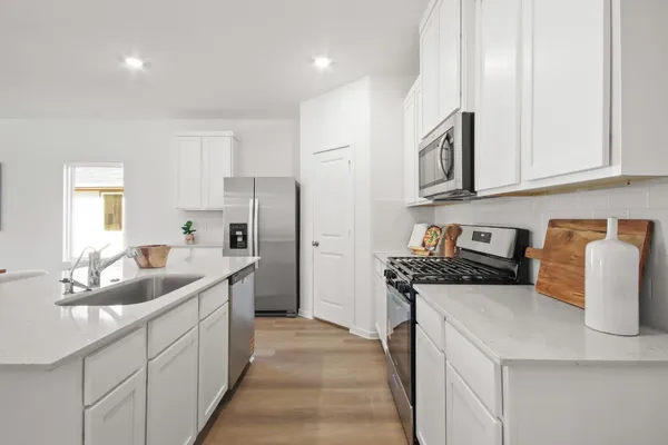 a kitchen with stainless steel appliances granite countertop a sink stove and refrigerator