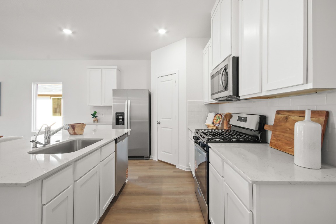 540 Wax Myrtle Way Hockley, TX 77447 - Photo 7 of 25 a kitchen with stainless steel appliances granite countertop a sink stove and refrigerator