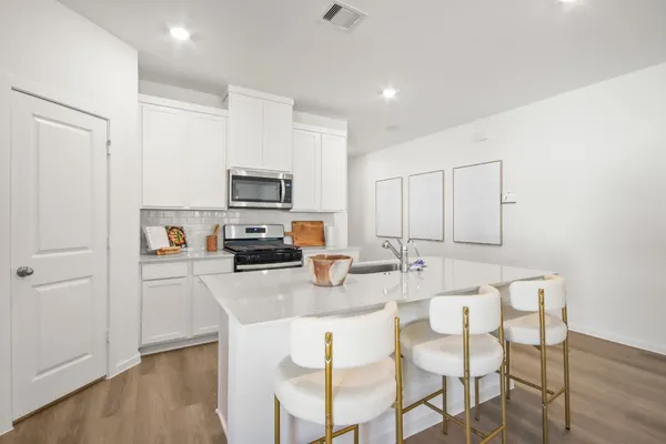 a kitchen with stainless steel appliances granite countertop a stove top oven a sink dishwasher and a refrigerator