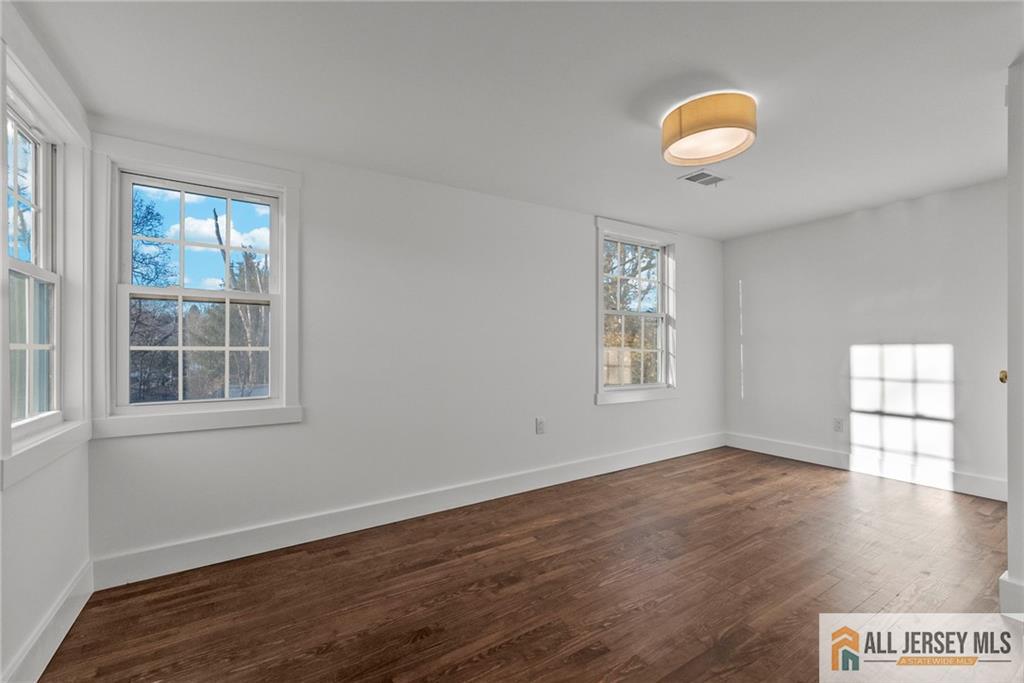143 Maple Avenue Chester, NJ 07930 - Photo 13 of 52 an empty room with wooden floor and windows