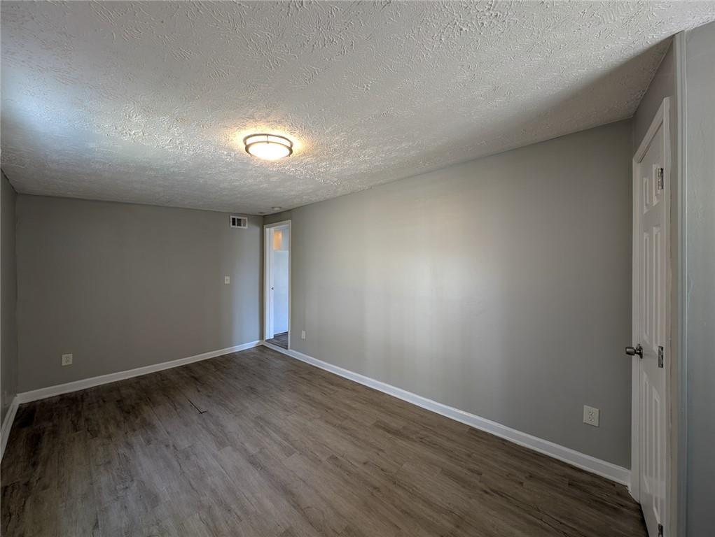 1672 Thornton Place Southwest Atlanta, GA 30315 - Photo 12 of 35 an empty room with wooden floor and windows