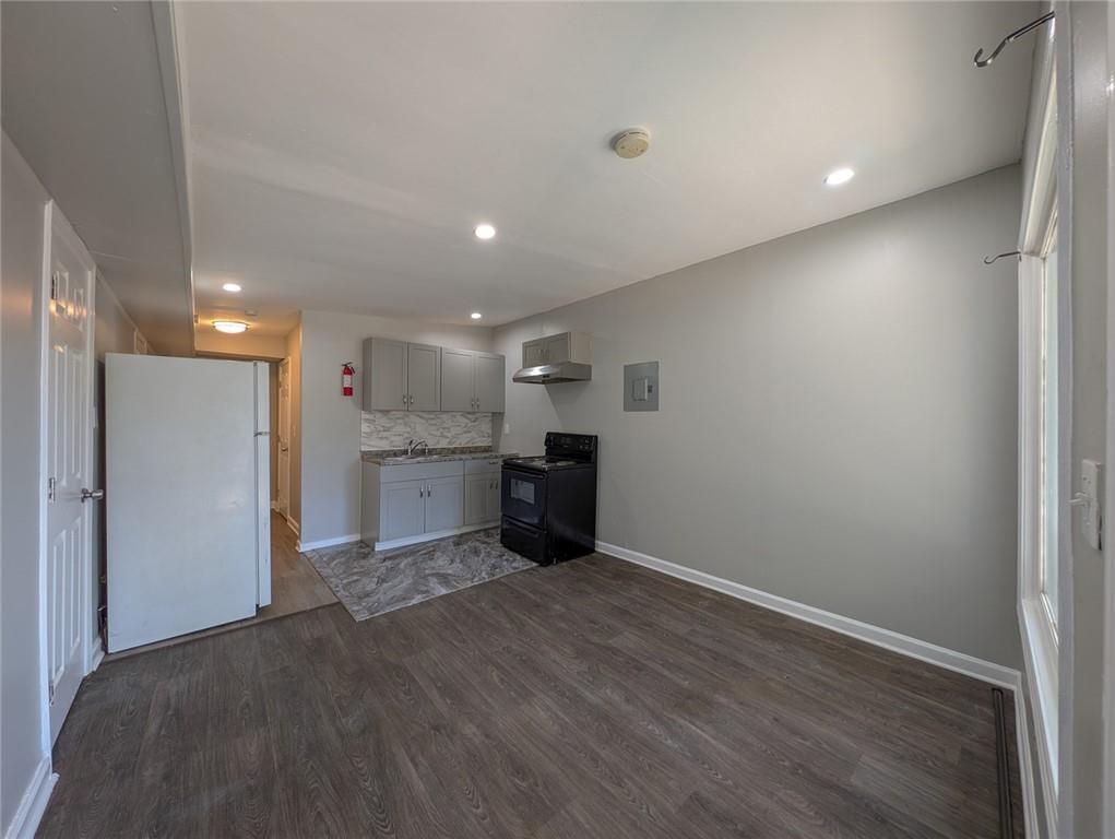 1672 Thornton Place Southwest Atlanta, GA 30315 - Photo 5 of 35 a view of an empty room with wooden floor and a kitchen
