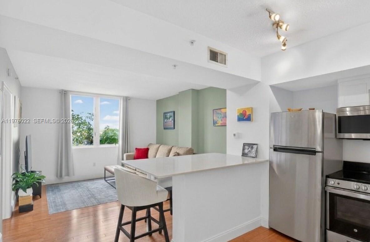 2630 Southwest 28th Street, Unit 51 Miami, FL 33133 - Photo 11 of 33 a kitchen with stainless steel appliances a refrigerator and a table