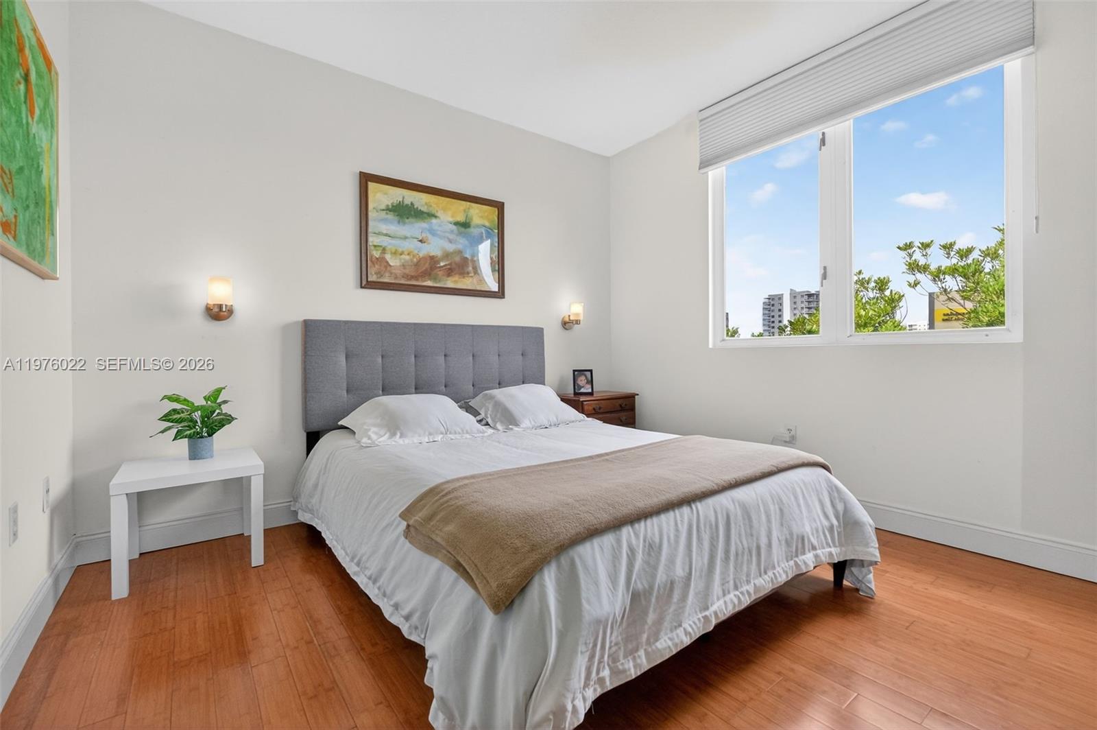 2630 Southwest 28th Street, Unit 51 Miami, FL 33133 - Photo 17 of 33 a bedroom with bed and painting on the wall