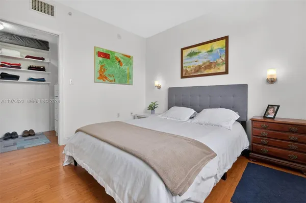 a bedroom with bed and painting on the wall