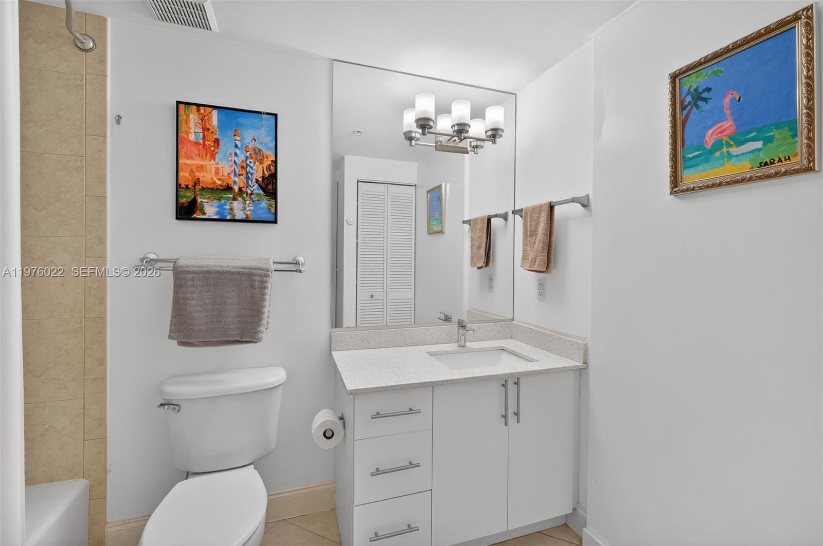 2630 Southwest 28th Street, Unit 51 Miami, FL 33133 - Photo 24 of 35 a bathroom with a toilet a sink and mirror