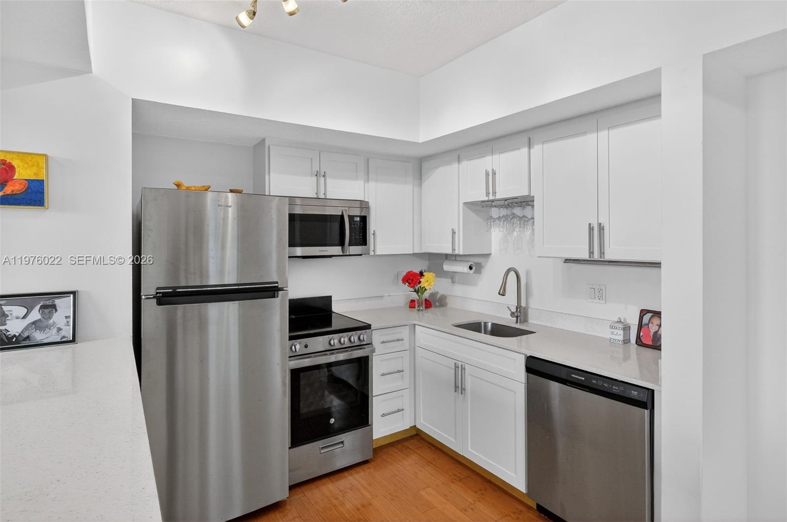 2630 Southwest 28th Street, Unit 51 Miami, FL 33133 - Photo 4 of 33 a kitchen with a refrigerator sink and wooden floor