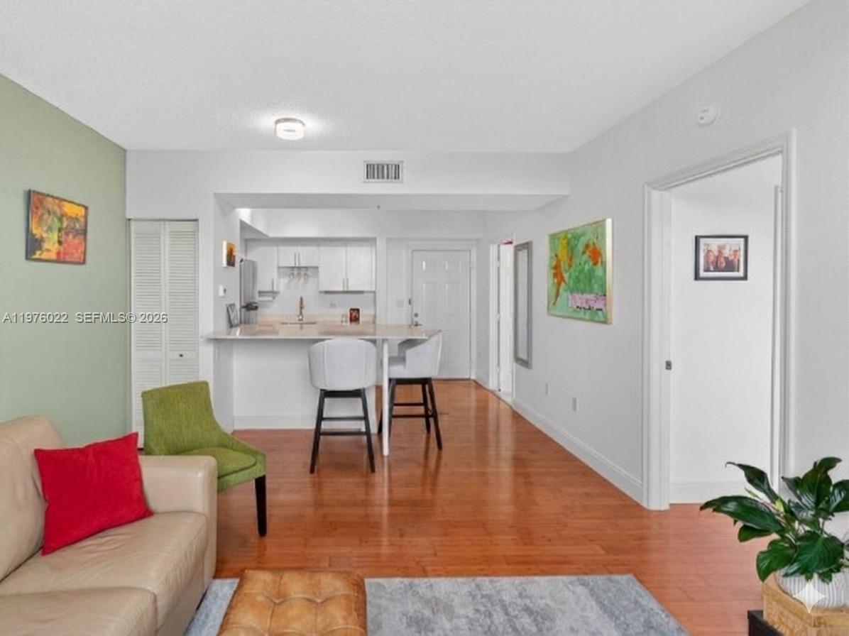 2630 Southwest 28th Street, Unit 51 Miami, FL 33133 - Photo 5 of 35 a living room with furniture and a wooden floor