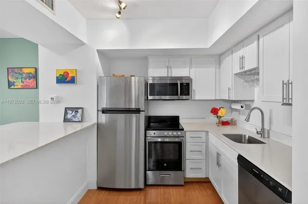 a kitchen with stainless steel appliances a refrigerator stove and sink