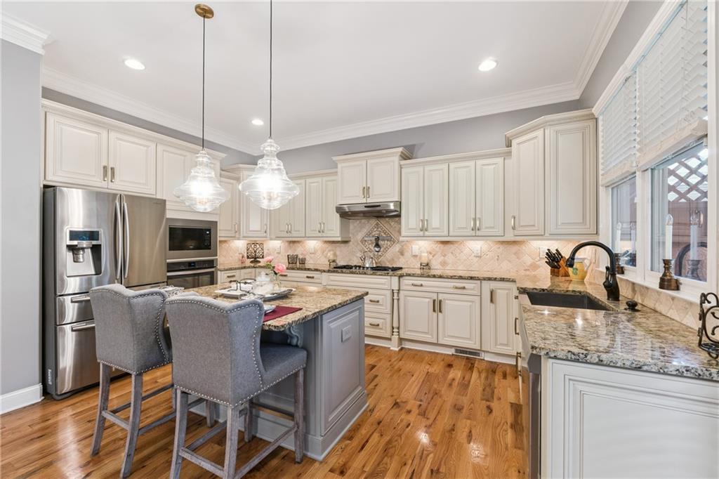 217 Trecastle Square Canton, GA 30114 - Photo 25 of 43 a kitchen with kitchen island granite countertop a sink a center island and stainless steel appliances